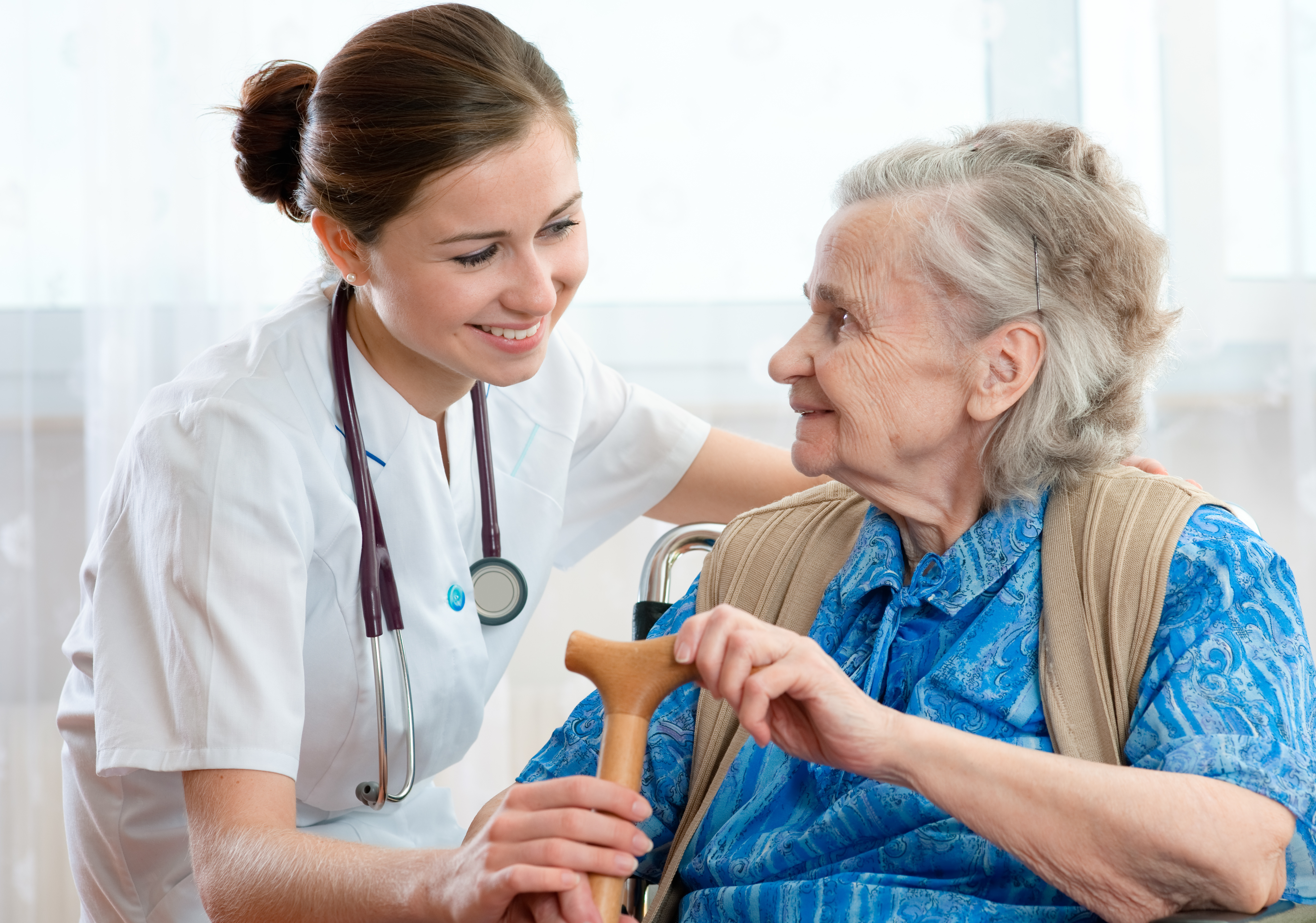 geriatric woman is visited by her doctor or caregiver
