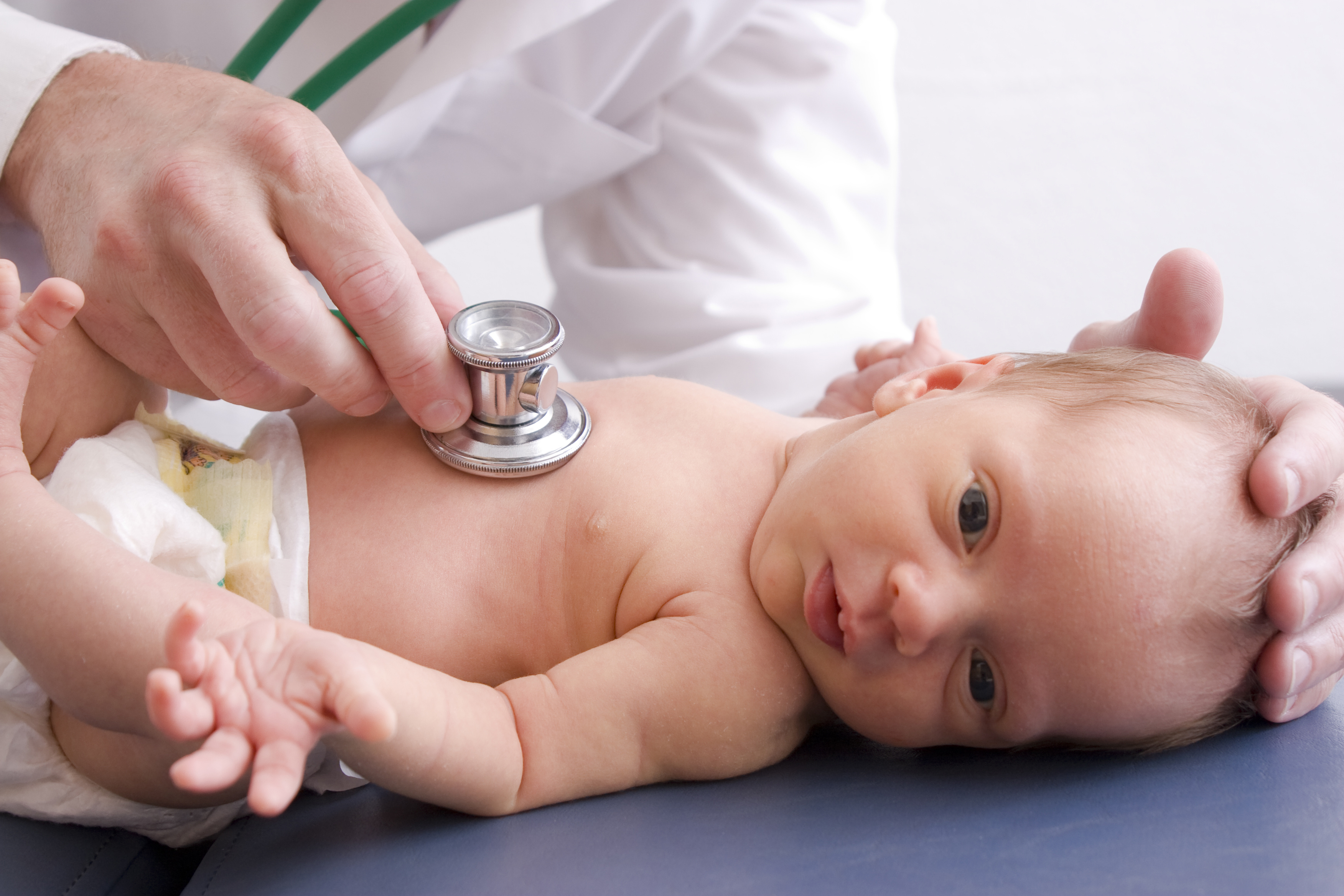 newborn baby with a neonatal doctor listening to her heart