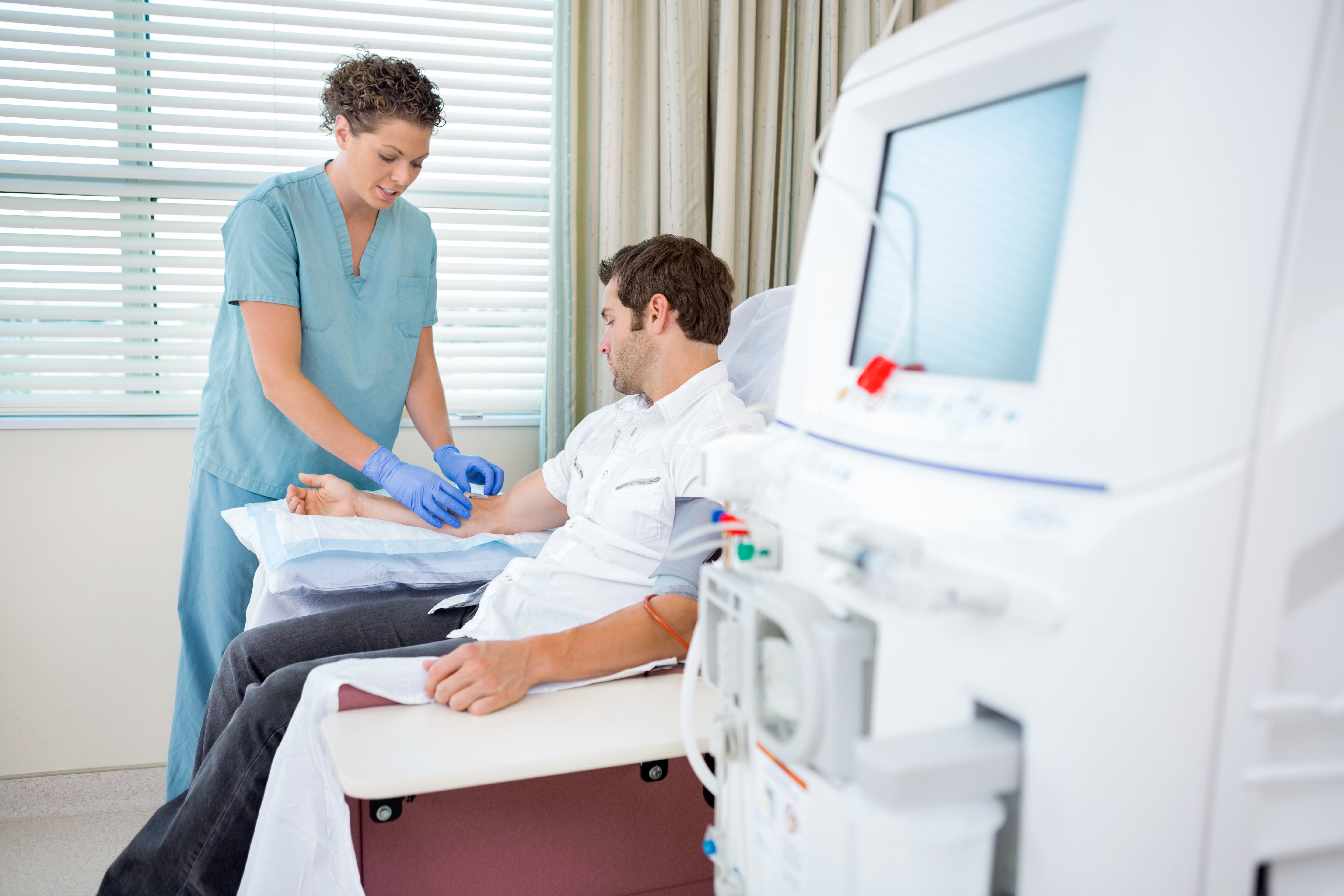 nephrologist injecting patient for renal dialysis treatment