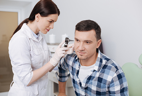 otolaryngologist examining patient's ear